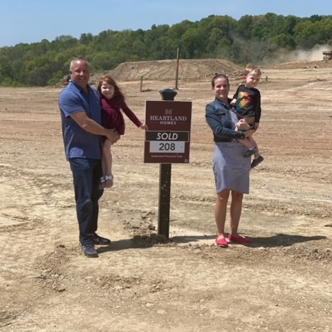 Family celebrating new home purchase at Heartland Homes lot