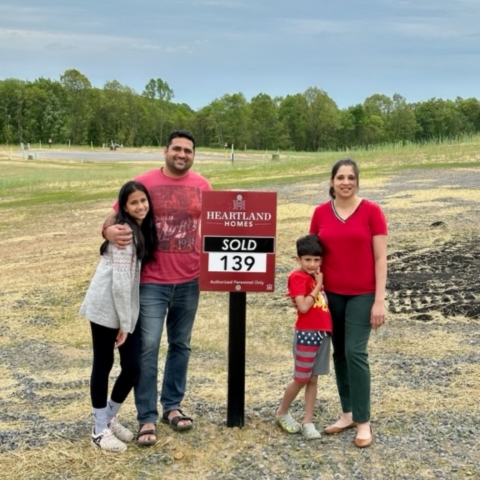 Family of four celebrating new home purchase on Heartland Homes lot