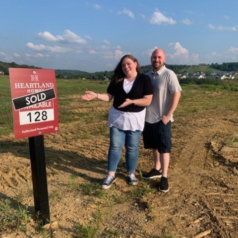 Couple celebrating new home purchase at Heartland Homes lot